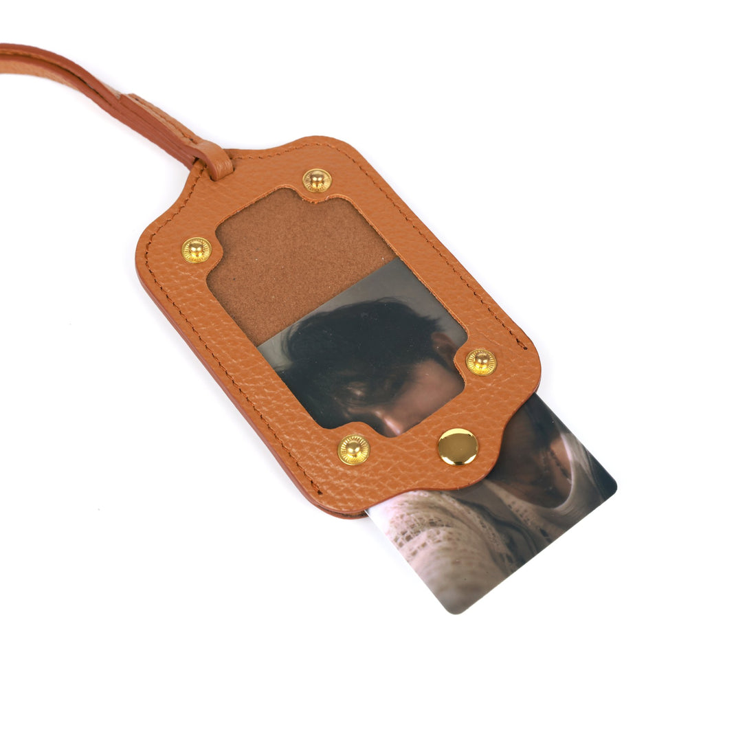 Photocard sliding out of the Aurekto Signature Case in Caramel Ivory leather